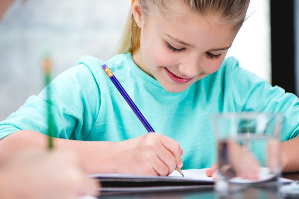 Child writing and smiling